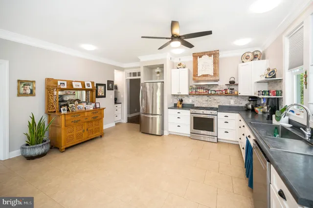 a kitchen with a refrigerator stove and white cabinets
