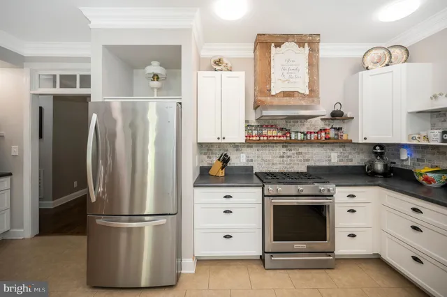 a kitchen with stainless steel appliances a white cabinets and a window