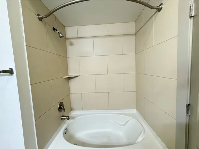 a bathroom with a white bath tub and a shower
