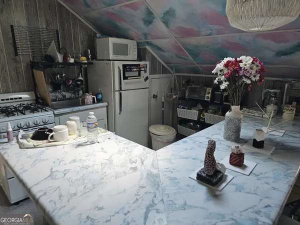 a kitchen with stainless steel appliances kitchen island granite countertop a sink stove and cabinets