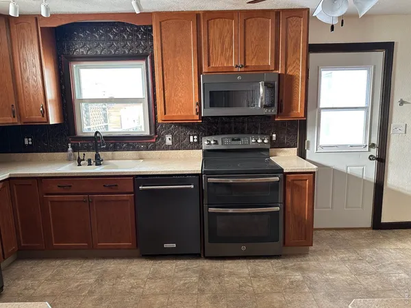 a kitchen with stainless steel appliances granite countertop a refrigerator and a sink