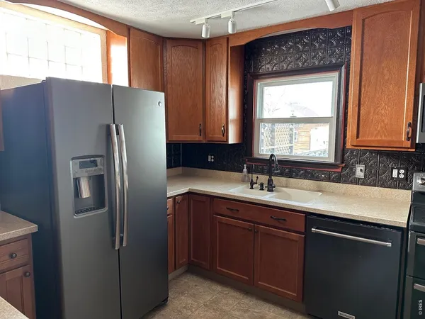a kitchen with granite countertop white cabinets and black appliances