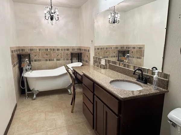 a bathroom with a granite countertop sink a toilet and mirror