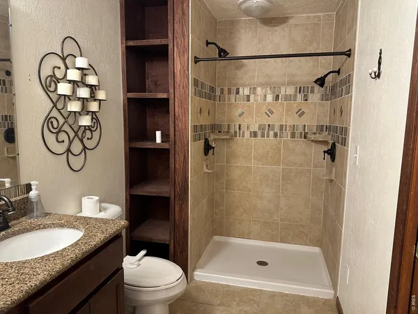 a bathroom with a granite countertop sink toilet and shower