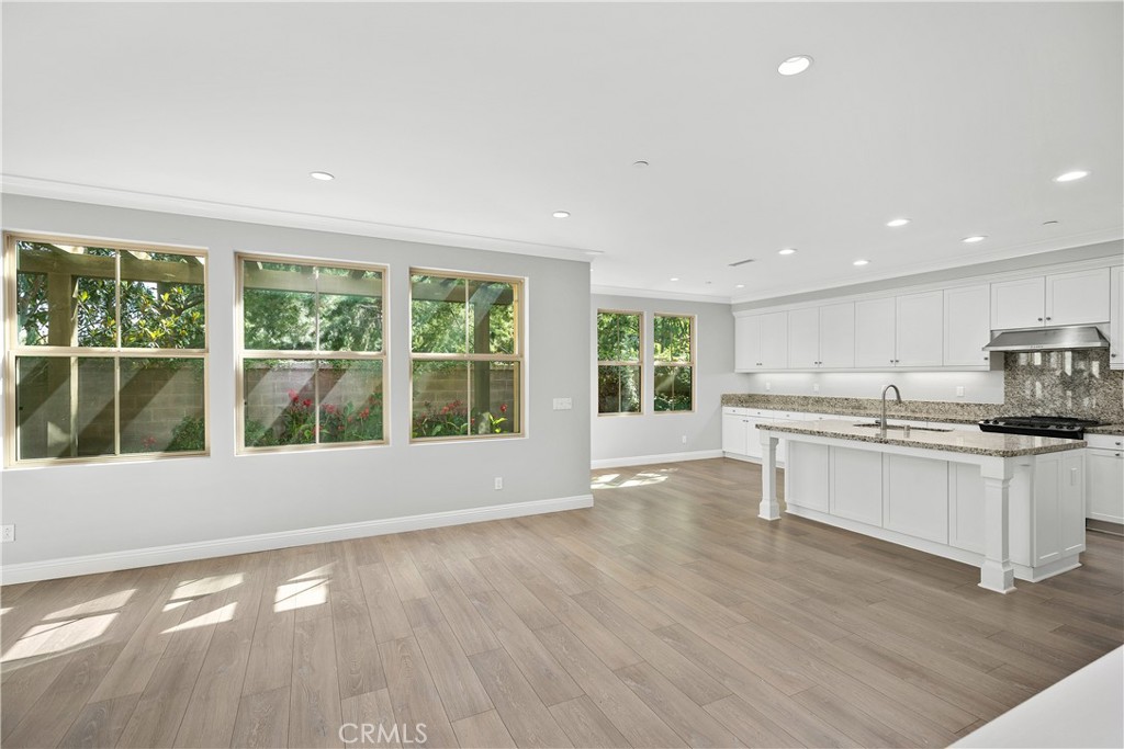 a view of kitchen with stainless steel appliances granite countertop a stove top oven a sink and a large window