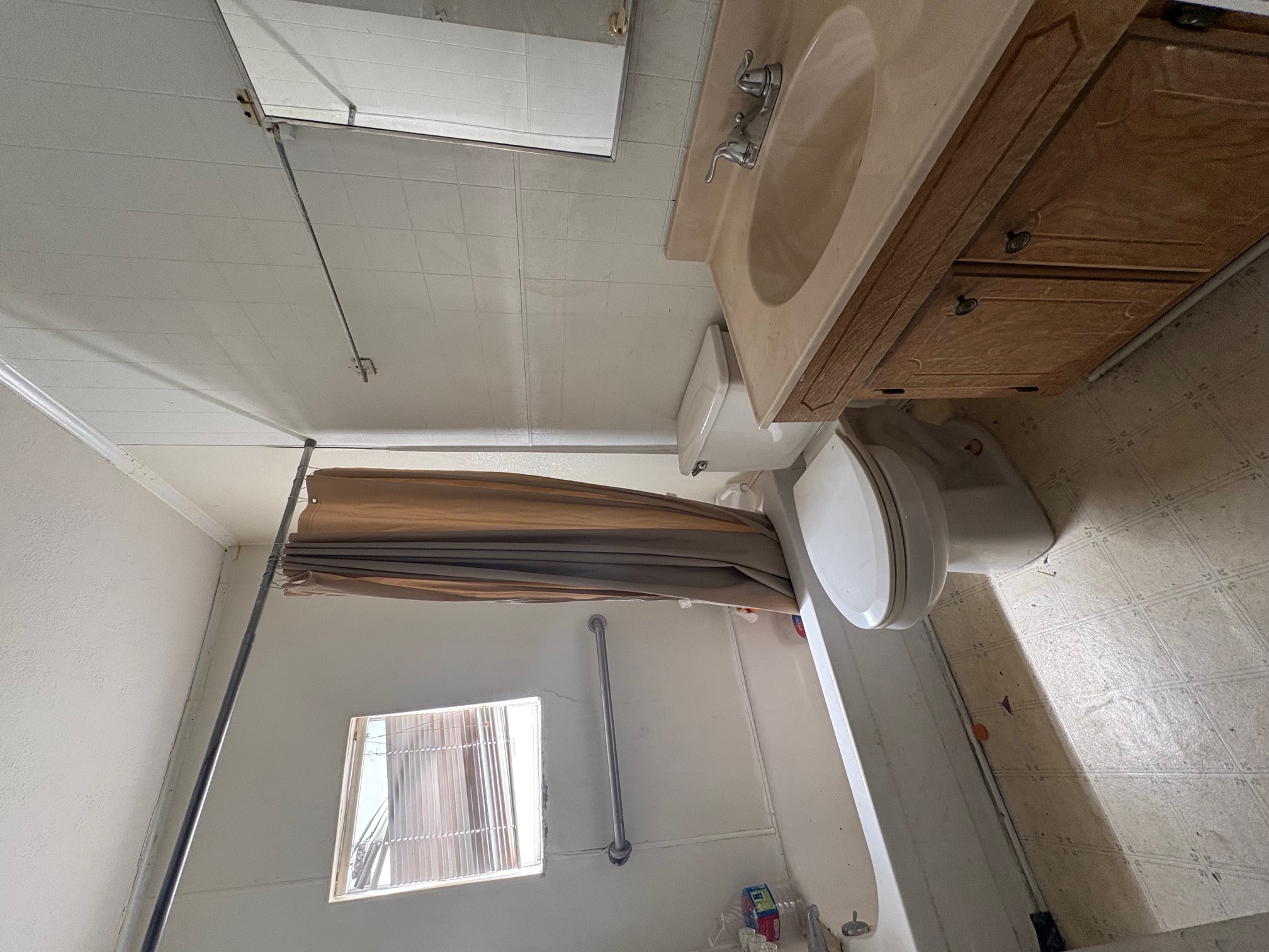 1400 Vargas Road Austin, TX 78741 - Photo 10 of 14 Bathroom featuring light floors, vanity, tile walls, shower / bath combo with shower curtain, and ornamental molding