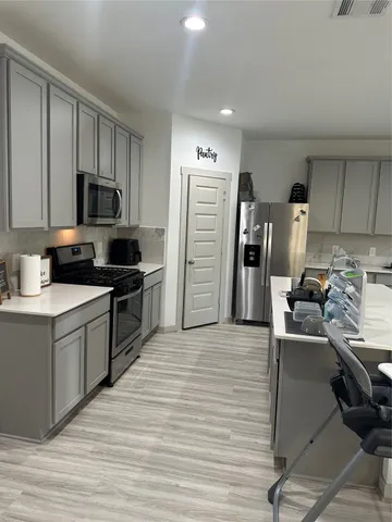a living room with furniture a rug and kitchen view