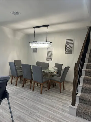 a view of a dining room with furniture wooden floor and chandelier