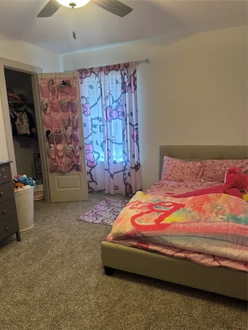 a bedroom with a bed next to a window