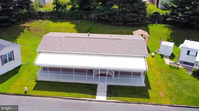 swimming pool view with a garden and outdoor seating