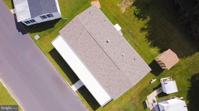 an aerial view of a house with a yard and a car park