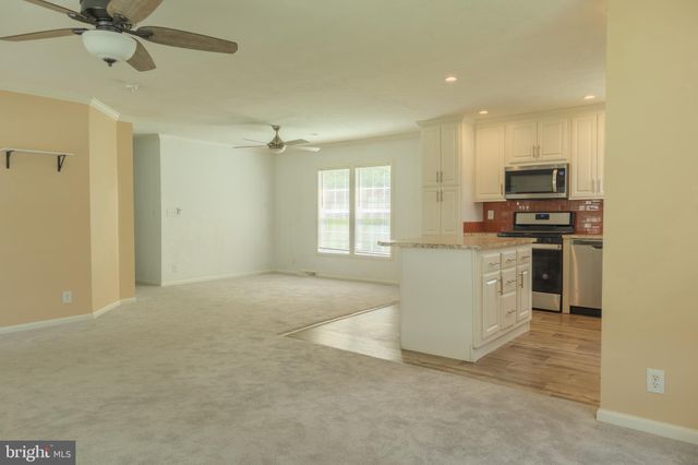 a view of a kitchen with a sink a refrigerator and window