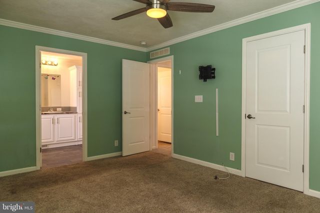 a view of a livingroom with a chandelier fan and a bathroom