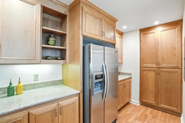 a kitchen with stainless steel appliances granite countertop a refrigerator and a sink