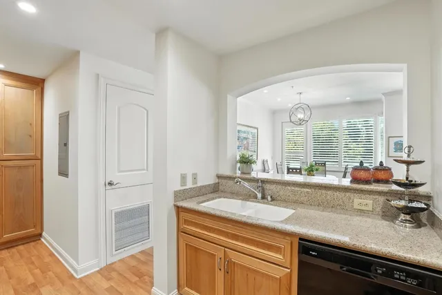 a view of a sink and dishwasher with wooden floor