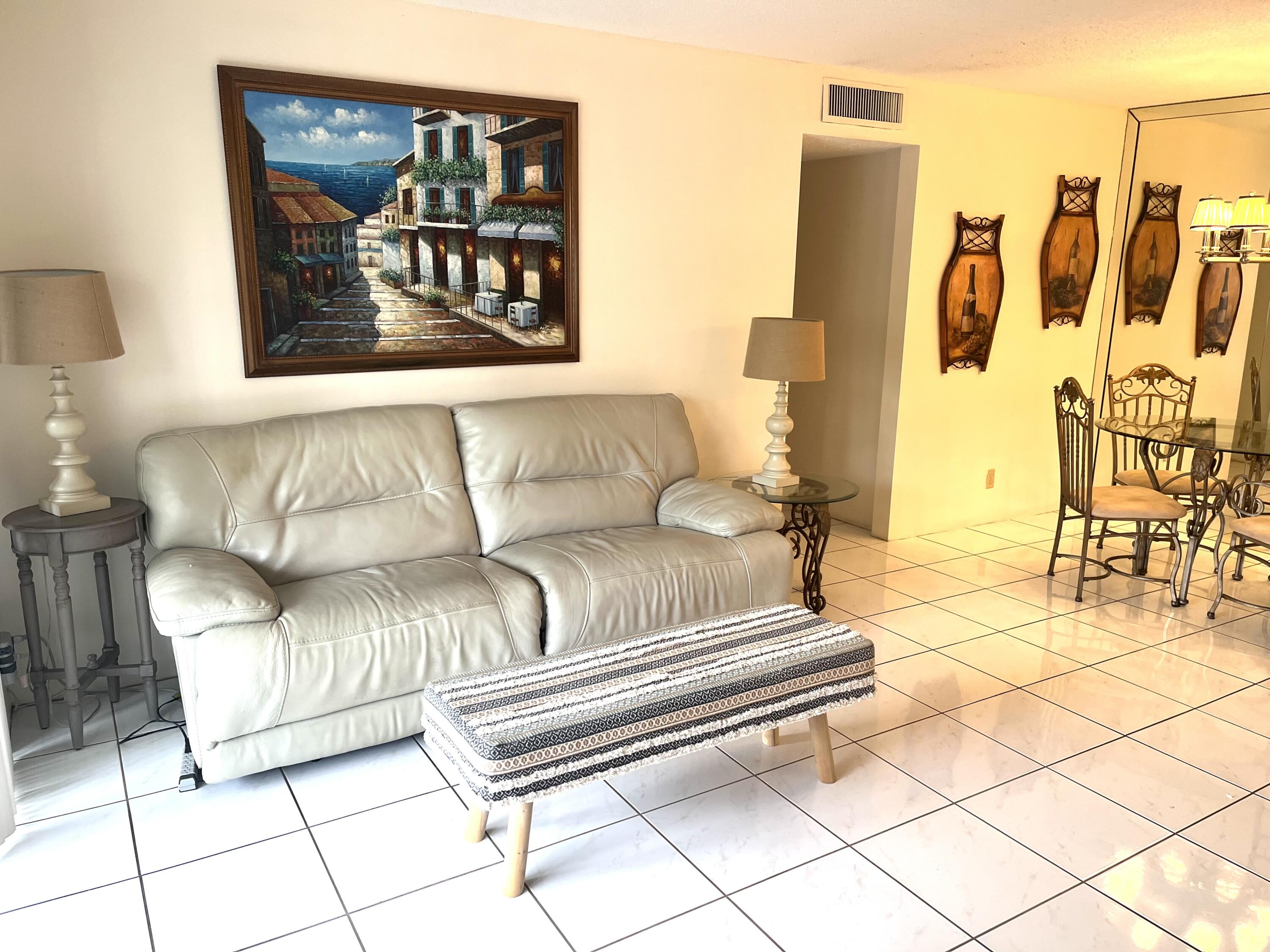 a living room with furniture and a painting on the wall