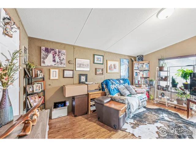 a living room with furniture a rug and a wall painting