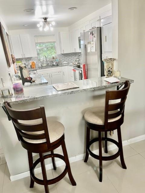 6100 Northwest 44th Street, Unit 405 Lauderhill, FL 33319 - Photo 15 of 46 a kitchen with stainless steel appliances kitchen island a table chairs sink and cabinets