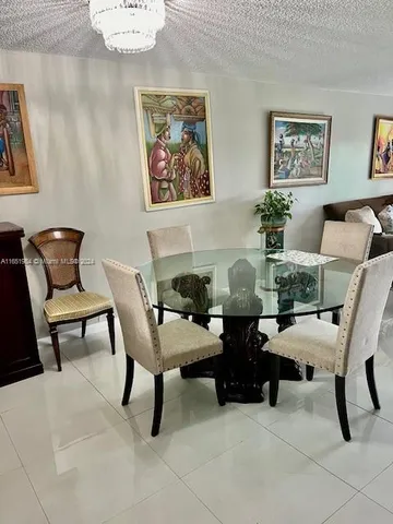 a dining room with furniture and paintings on the wall