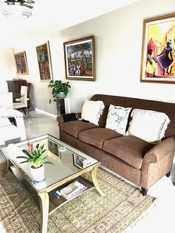 a living room with furniture and painting on the wall