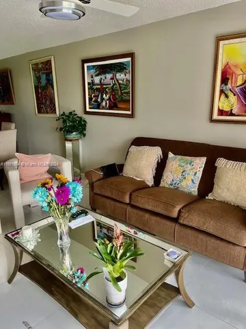a living room with furniture flowerpot and a chandelier