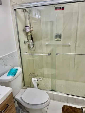 a white toilet sitting next to a bathroom sink and shower