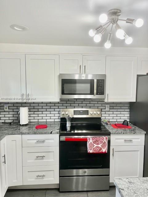 6100 Northwest 44th Street, Unit 405 Lauderhill, FL 33319 - Photo 10 of 46 a kitchen with granite countertop a stove and a microwave