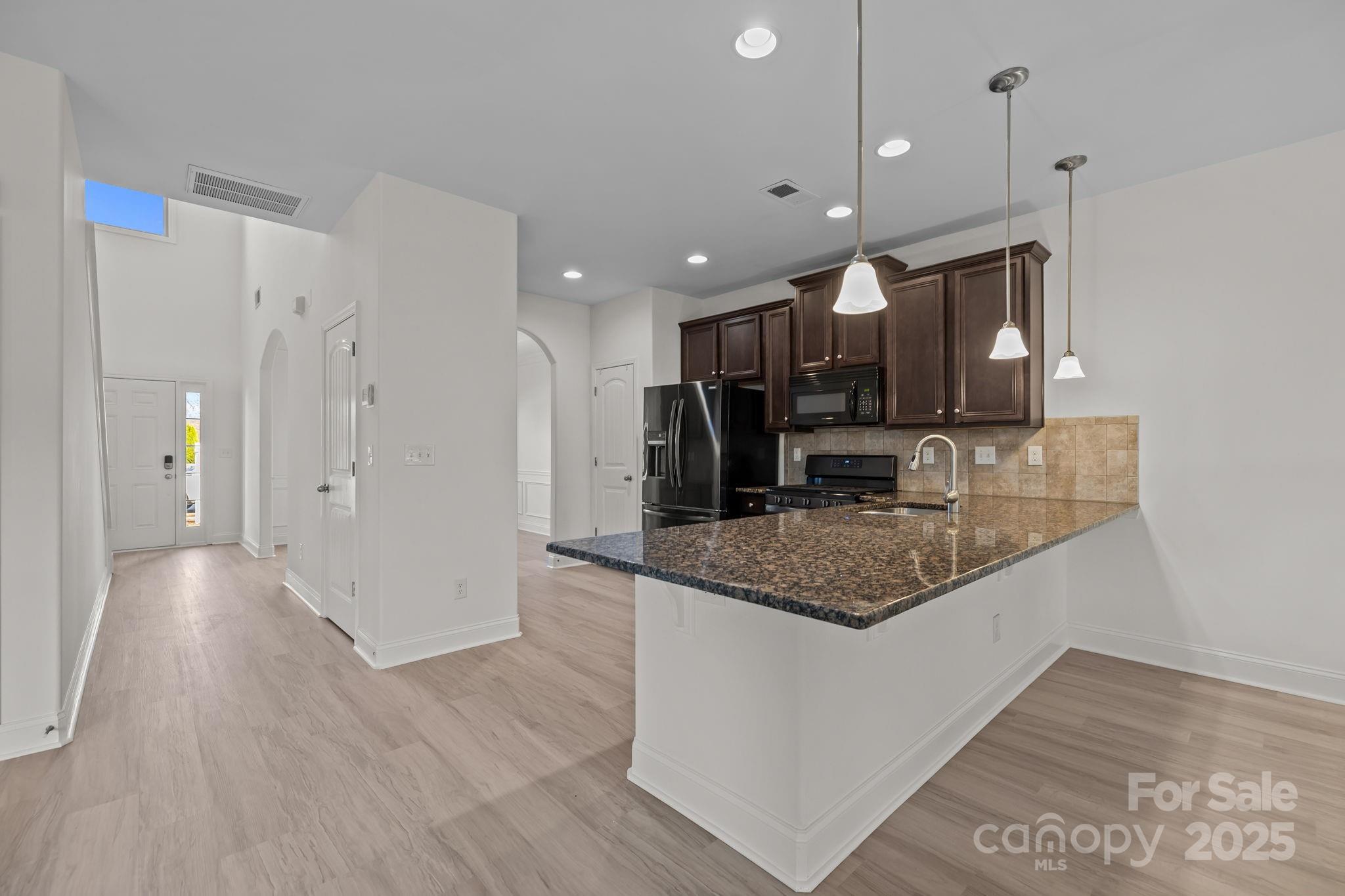 7020 Sedgewick Road Indian Trail, NC 28079 - Photo 11 of 42 a kitchen with stainless steel appliances granite countertop a sink refrigerator and cabinets