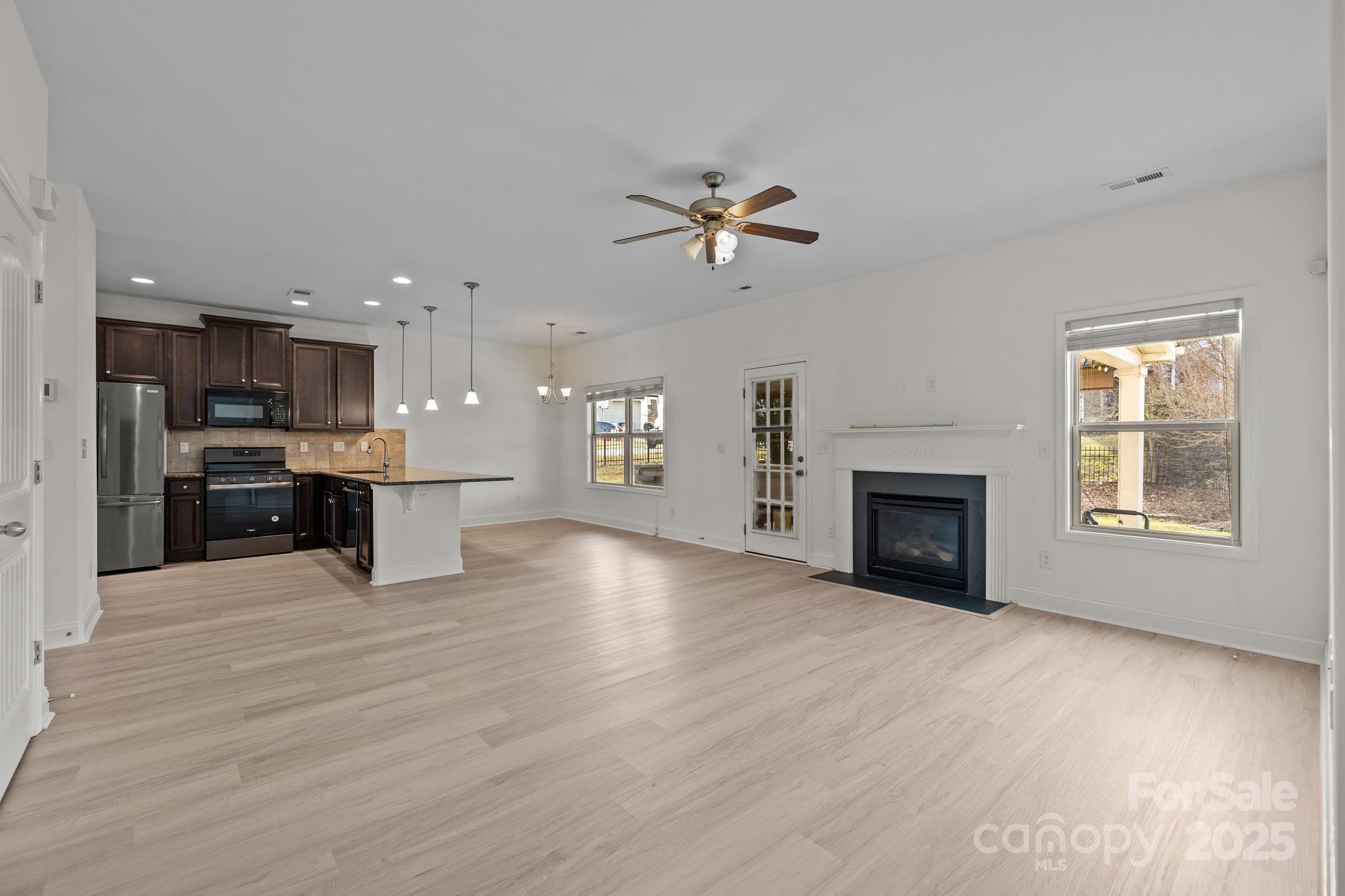 7020 Sedgewick Road Indian Trail, NC 28079 - Photo 15 of 42 a view of an empty room with a kitchen and a fireplace