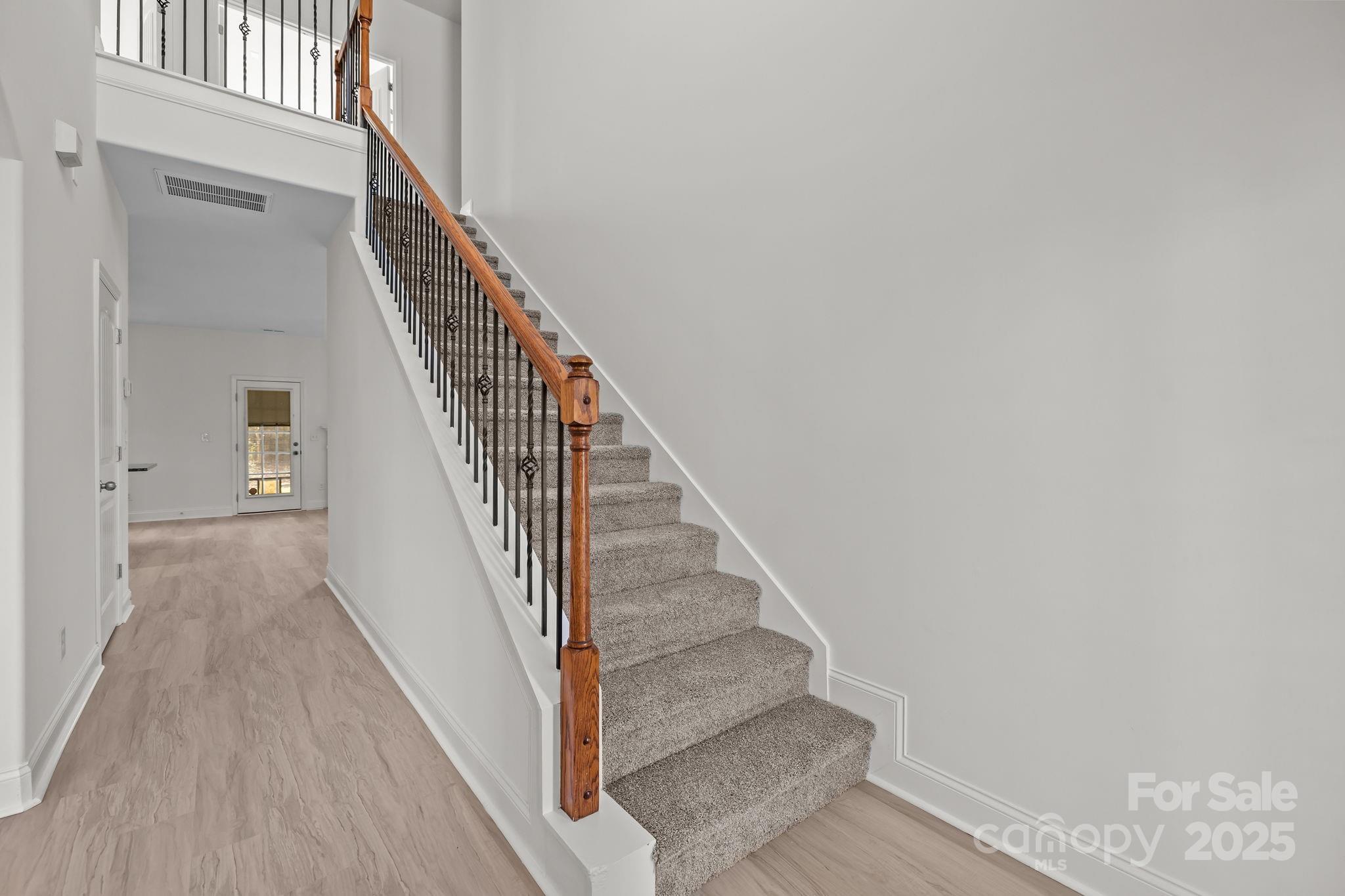 7020 Sedgewick Road Indian Trail, NC 28079 - Photo 19 of 42 a view of staircase with wooden floor and white walls