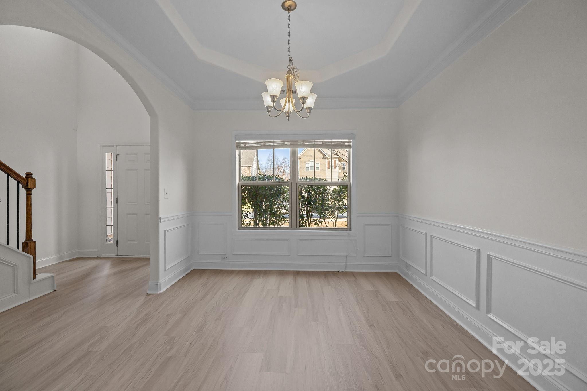 7020 Sedgewick Road Indian Trail, NC 28079 - Photo 5 of 42 an empty room with wooden floor chandelier and windows