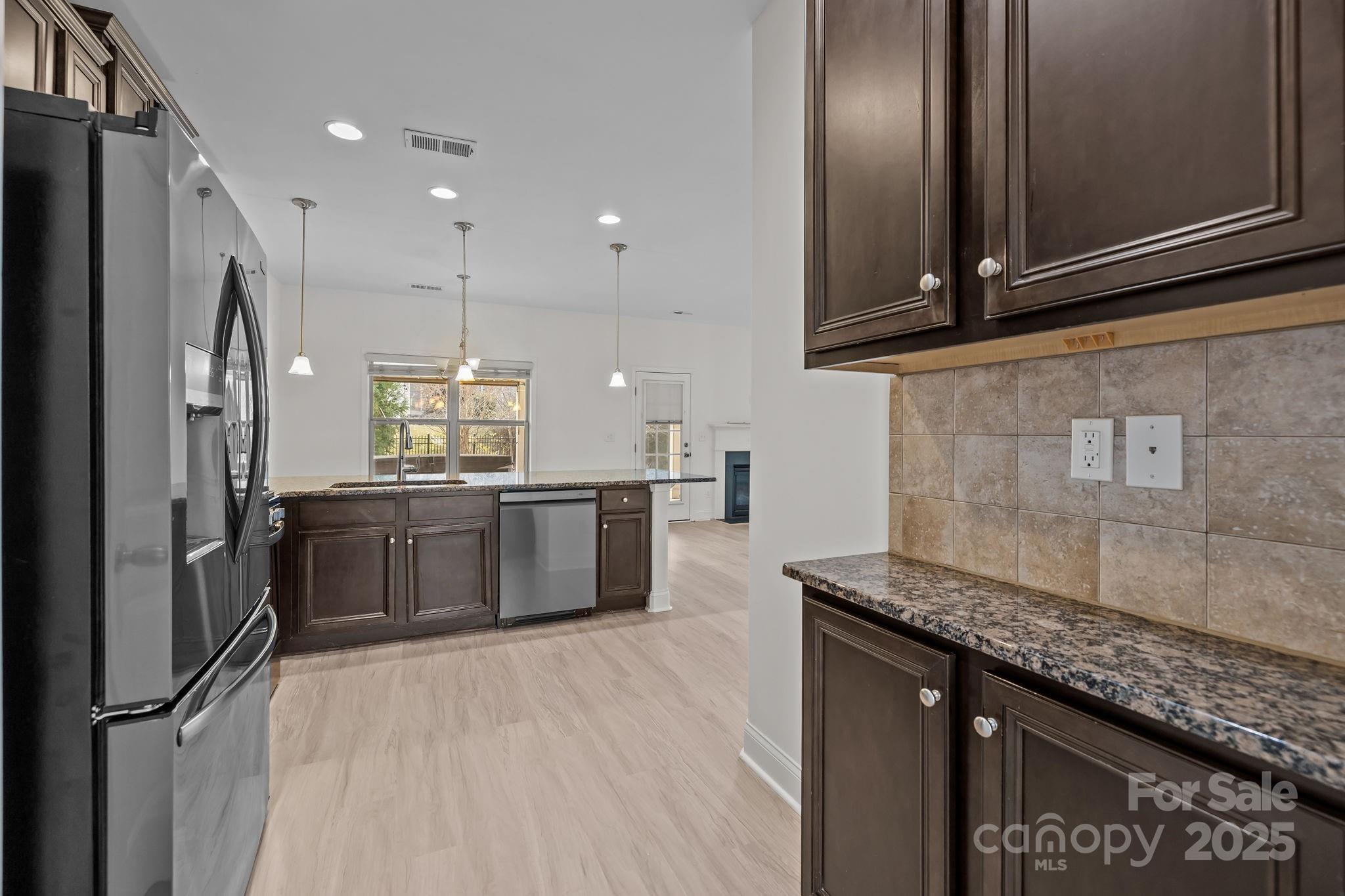 7020 Sedgewick Road Indian Trail, NC 28079 - Photo 6 of 42 a kitchen with stainless steel appliances granite countertop a refrigerator a sink and wooden cabinets