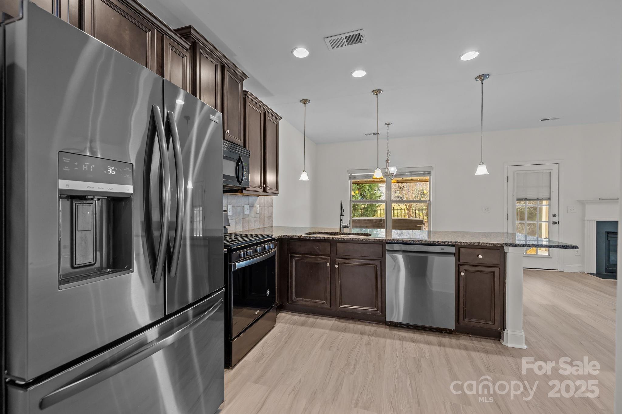 7020 Sedgewick Road Indian Trail, NC 28079 - Photo 7 of 42 a large kitchen with stainless steel appliances granite countertop a refrigerator a stove a sink and a microwave
