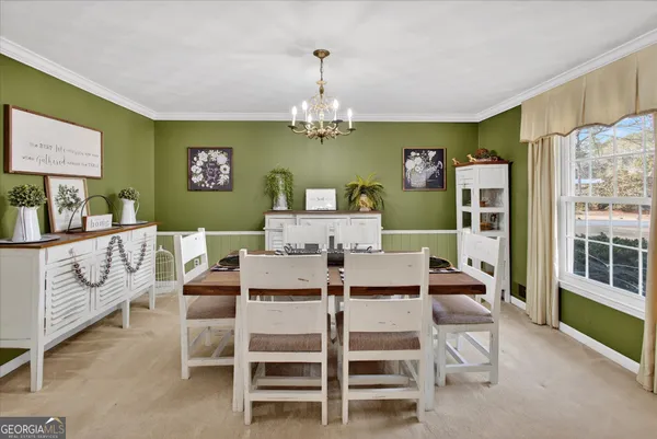 a view of a dining room with furniture a livingroom and chandelier