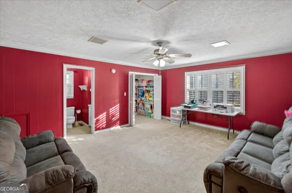 a living room with furniture a ceiling fan and a window