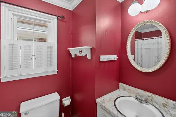 a bathroom with a toilet a sink and mirror
