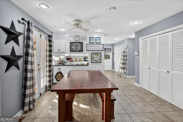 a kitchen with stainless steel appliances kitchen island granite countertop a refrigerator a stove a oven a sink dishwasher and white cabinets with wooden floor