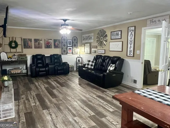 a kitchen with stainless steel appliances kitchen island granite countertop a refrigerator a stove a oven a sink dishwasher and white cabinets with wooden floor