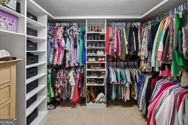 a view of walk in closet with clothes