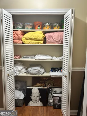 a bedroom with a large bed and a flat tv screen on dresser