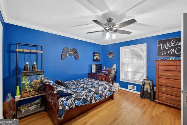 a bedroom with a bed and wooden floor