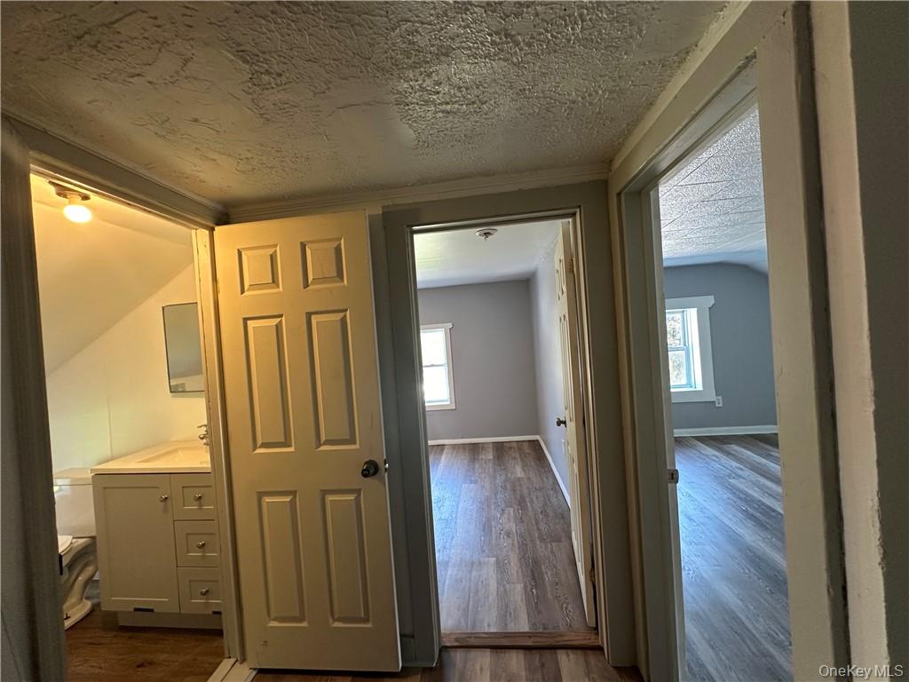 1399 State Rte 55, Unit 11 Clintondale, NY 12515 - Photo 20 of 21 Corridor featuring a textured ceiling, plenty of natural light, and dark hardwood / wood-style flooring