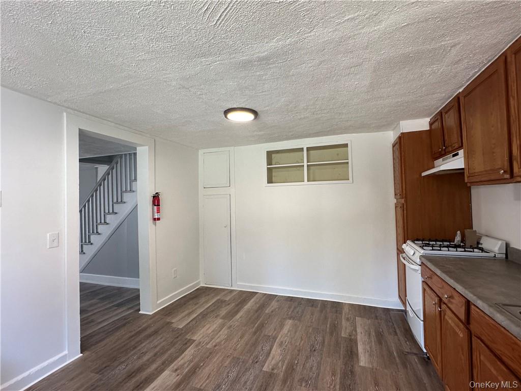 1399 State Rte 55, Unit 11 Clintondale, NY 12515 - Photo 6 of 21 Kitchen featuring dark wood-type flooring, a textured ceiling, and white range with gas cooktop