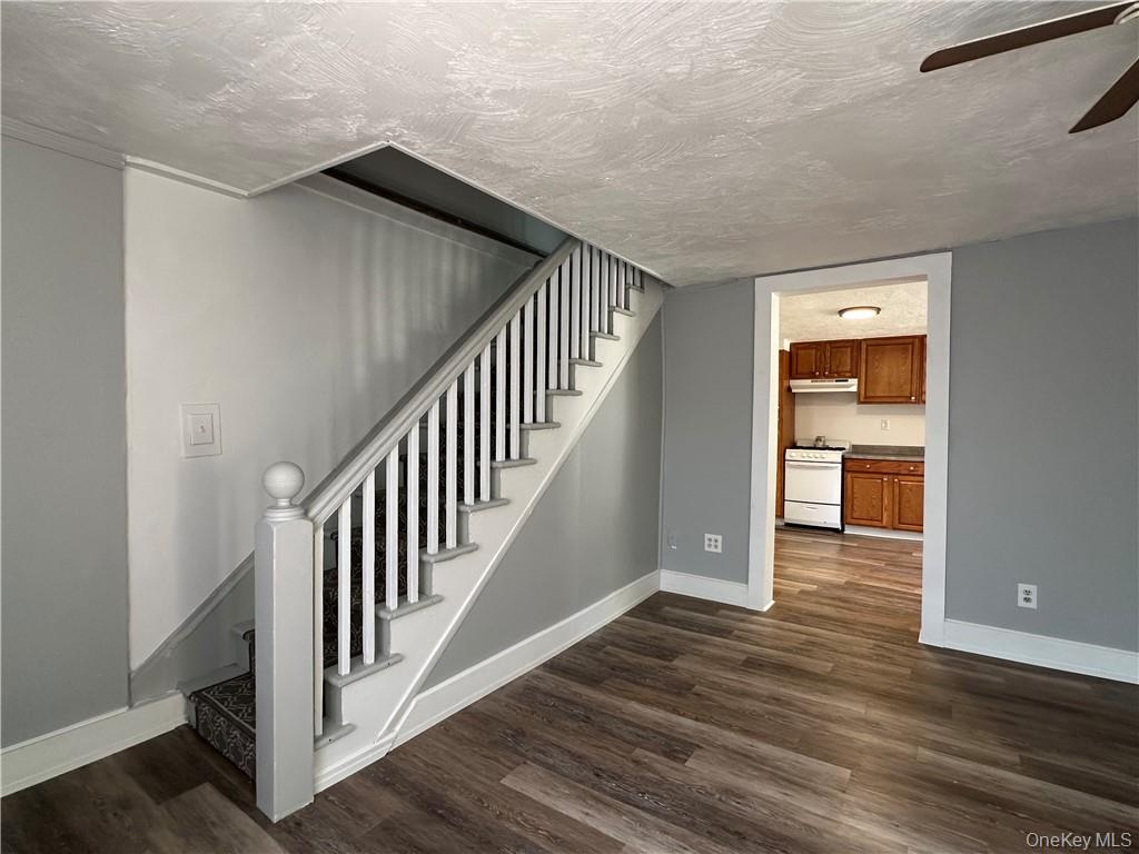 1399 State Rte 55, Unit 11 Clintondale, NY 12515 - Photo 9 of 21 Stairway featuring wood-type flooring, a textured ceiling, and ceiling fan