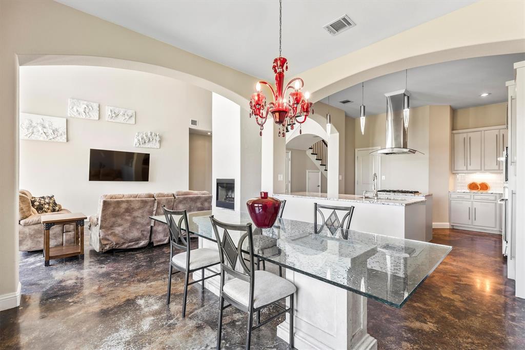 Dining room featuring concrete flooring, arched walkways, and recessed lighting