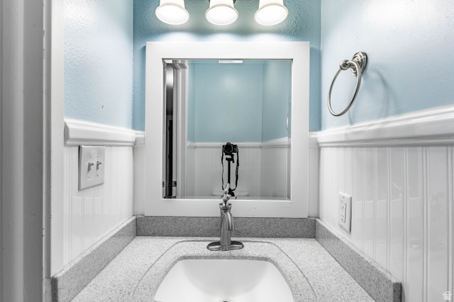 728 400 East Orem, UT 84097 - Photo 10 of 30 Bathroom vanity featuring a speckled countertop, integrated sink, and brushed nickel faucet
