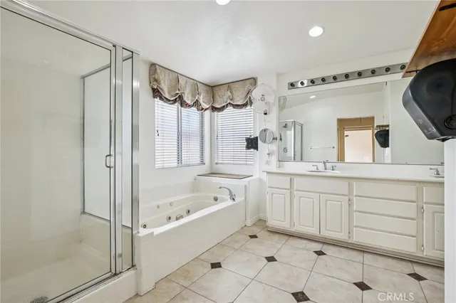 a bathroom with a bathtub a sink a window and a shower