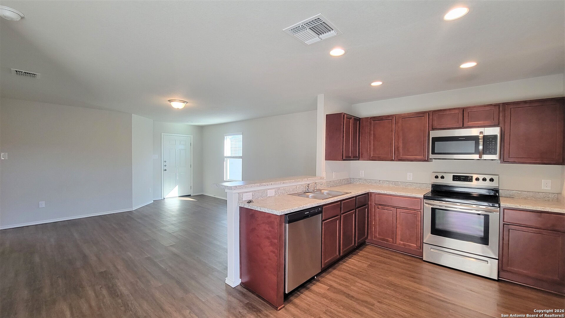 7136 Quarter Moon Converse, TX 78109 - Photo 3 of 22 a kitchen with stainless steel appliances granite countertop a stove top oven a sink dishwasher and wooden cabinets with wooden floor