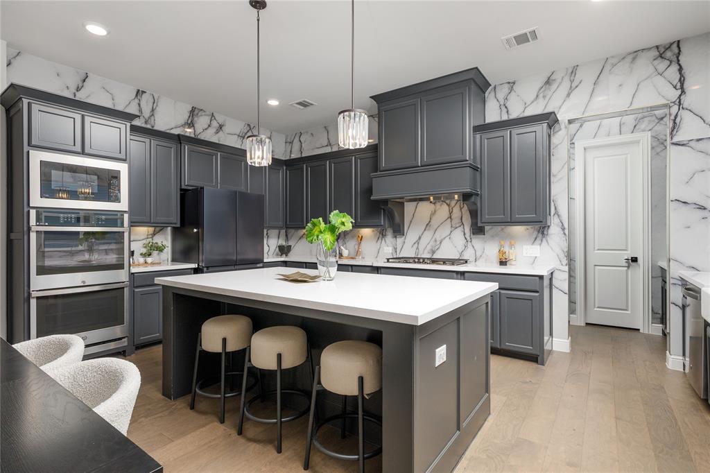 7409 Cormac Street McKinney, TX 75071 - Photo 14 of 40 The kitchen is equipped with double ovens, microwave, gas cooktop and large gathering island.