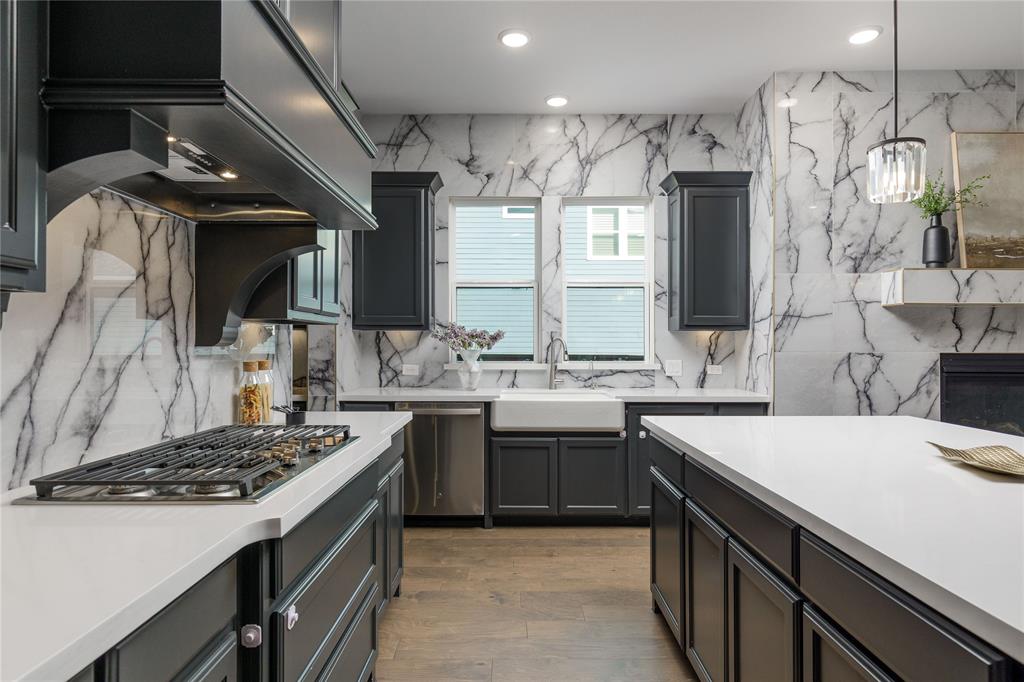 7409 Cormac Street McKinney, TX 75071 - Photo 15 of 40 The kitchen is equipped with a farm sink, double ovens, microwave, gas cooktop and large gathering island.